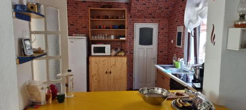 a kitchen with a yellow counter top and a brick wall at Green Villa 
