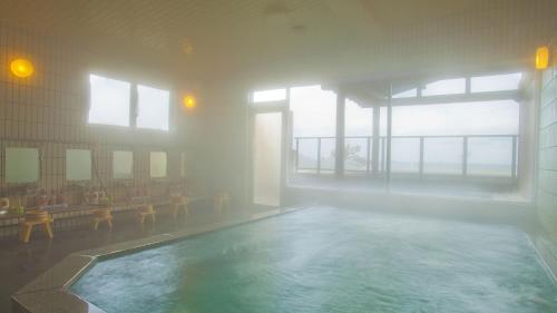 uma grande piscina num edifício com uma grande janela em Michishio em Toba