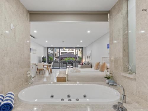 a large white bath tub in a living room at Santai Resort - Holiday Management in Kingscliff