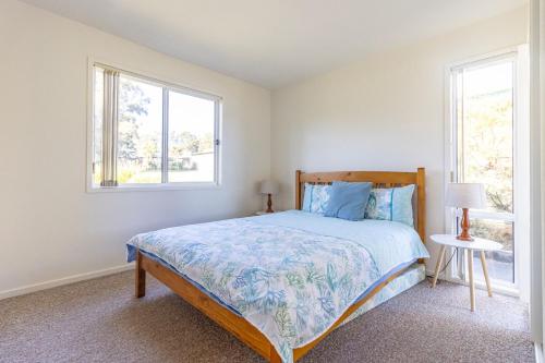 1 dormitorio con 1 cama y 2 ventanas en Berrara Lagoon Front Chalet, en Berrara