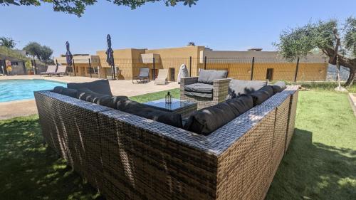une terrasse avec des canapés, une table et une piscine dans l'établissement 3 pièces dans villa avec piscine, à Nice