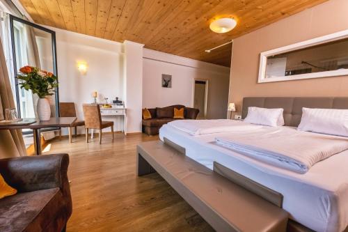 a bedroom with a large bed and a living room at Landhaus Ramsau in Ramsau am Dachstein