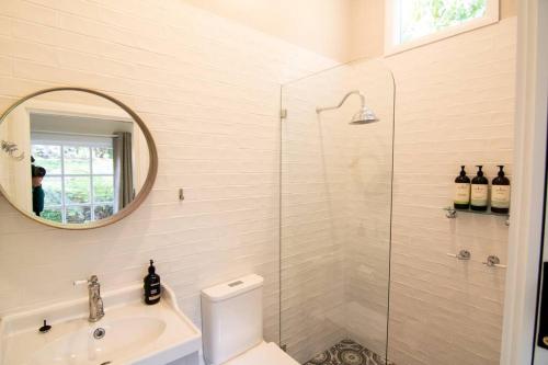 bagno con servizi igienici, lavandino e specchio di Bottlebrush Cabin, cosy private cabin in the trees a Leura