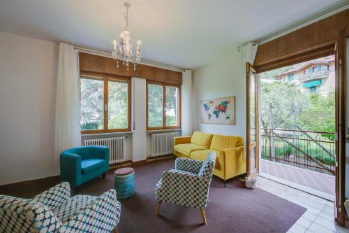 d'un salon avec un canapé et des fauteuils jaunes. dans l'établissement The Bon'Ora Apartment - Happy Rentals, à Riva del Garda