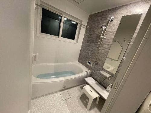 La salle de bains est pourvue d'une baignoire, de toilettes et d'un lavabo. dans l'établissement Blueberry Apartment, à Iiyama