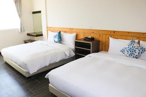 a bedroom with two beds and a mirror at 紫龍星空民宿 in Leye