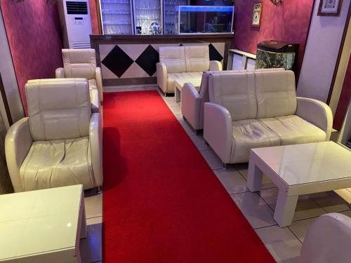 a waiting room with white chairs and a red carpet at Red White Hotel in Istanbul