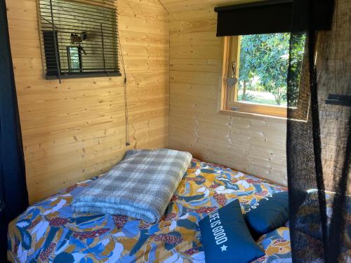 1 dormitorio con 1 cama en una cabaña de madera en Roulotte , hébergement atypique en Solliès-Pont