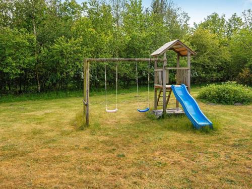 a playground with a slide and a swing at 6 person holiday home in Vemb-By Traum in Vemb