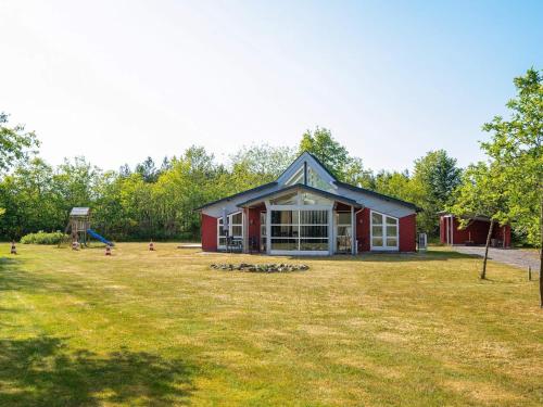 a red building with a playground in a yard at 6 person holiday home in Vemb-By Traum in Vemb