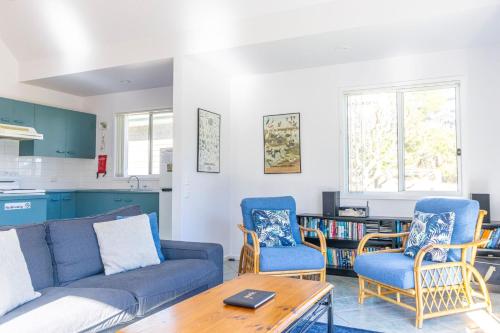 a living room with a couch and two chairs and a table at Kangaroo Cabin in Berrara