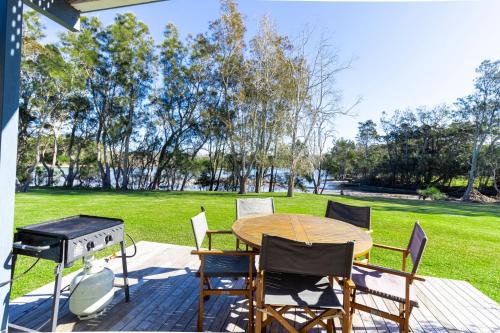 a patio with a table and chairs and a grill at Kangaroo Cabin in Berrara