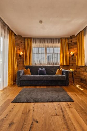 a living room with a couch and a rug at Landhaus Ramsau in Ramsau am Dachstein