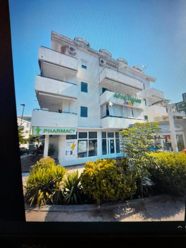 a large white building with plants in front of it at Filip Apartman - Zgrada Jolly Apartmani in Budva