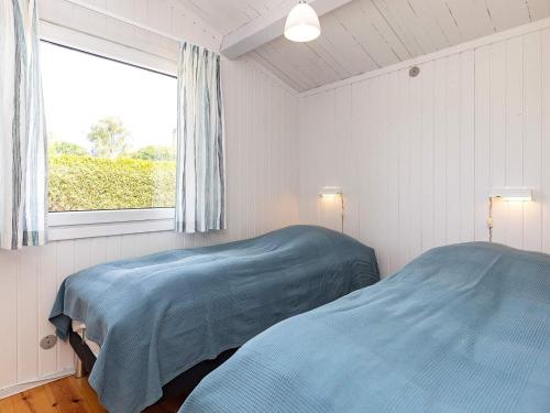 1 dormitorio con 2 camas y ventana en Holiday home Faxe Ladeplads IX, en Fakse Ladeplads