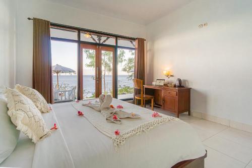 a bedroom with a bed with a view of the ocean at Goa Giri Hill Bungalow in Nusa Penida