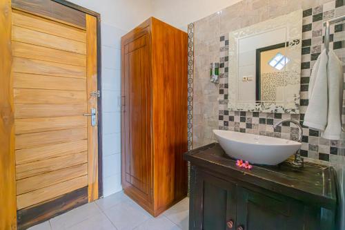 een badkamer met een wastafel en een spiegel bij Goa Giri Hill Bungalow in Nusa Penida
