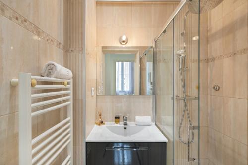 ein Bad mit einem Waschbecken und einer Dusche in der Unterkunft Appartements les Lions in Nizza