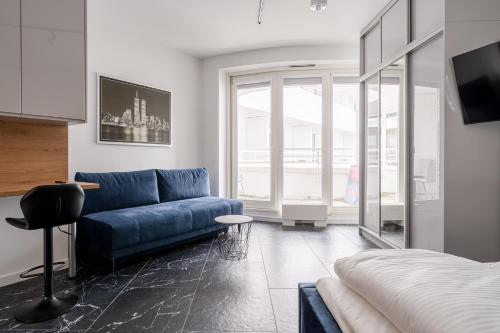 a living room with a blue couch and a bed at RentPlanet - Apartamenty OVO in Wrocław