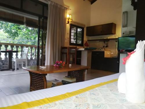 a kitchen and living room with a table in a room at Romance Bungalows in Beau Vallon
