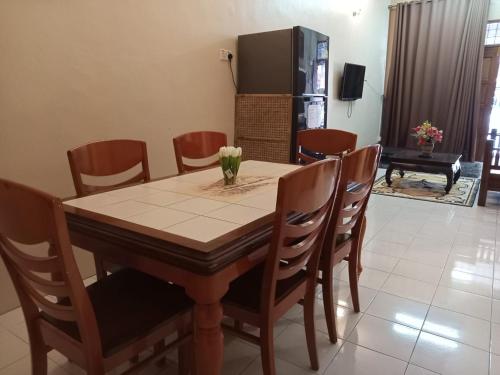 d'une salle à manger avec une table, des chaises et un réfrigérateur. dans l'établissement Ria homestay & kids pool, à Alor Setar