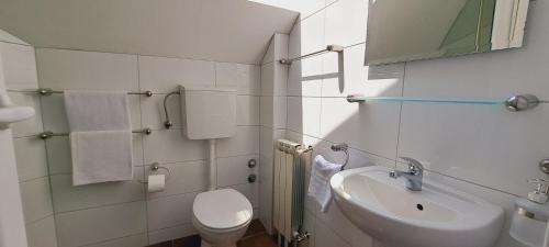 Baño blanco con aseo y lavamanos en Magellan Apartments en Belgrado