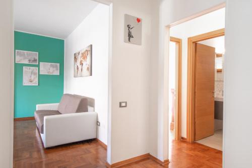 ein Wohnzimmer mit einem weißen Stuhl und blauen Wänden in der Unterkunft Piombino Apartments - Casa Marconi in Piombino