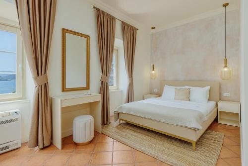 a bedroom with a white bed and a window at Vila Perast Boutique Hotel in Perast
