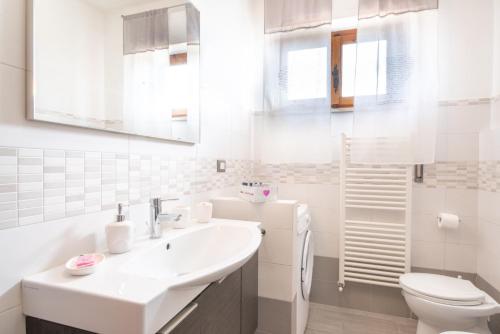 Baño blanco con lavabo y aseo en Piombino Apartments - Casa Marconi en Piombino
