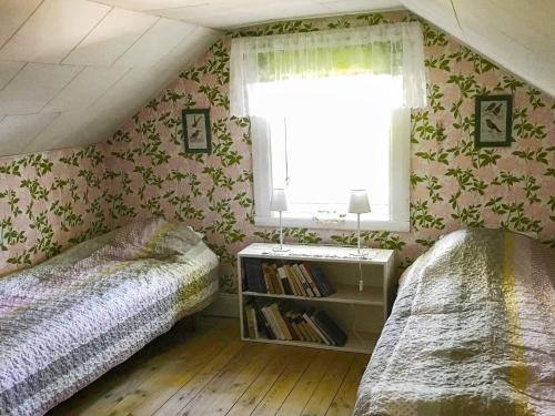 sypialnia na poddaszu z 2 łóżkami i oknem w obiekcie Holiday home Tystberga III w mieście Tystberga
