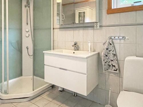 uma casa de banho com um lavatório e um chuveiro em Holiday home VAREKIL VI em Varekil
