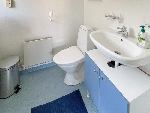 ein Badezimmer mit einem weißen WC und einem Waschbecken in der Unterkunft Holiday home SÖLVESBORG X in Sölvesborg