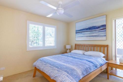 ein Schlafzimmer mit einem Bett und zwei Fenstern in der Unterkunft Sea Shell Chalet at Berrara Chalets in Berrara