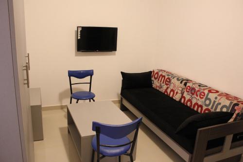 a living room with a couch and two chairs and a table at Le Caravelle Beirut in Beirut