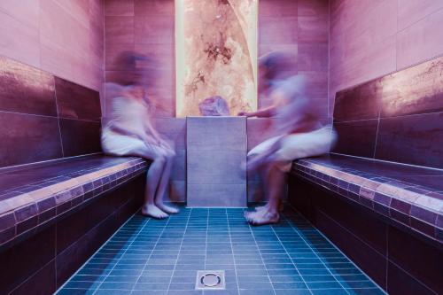 two people sitting on benches in a jacuzzi at Hotel St. Georg zum See in Maurach