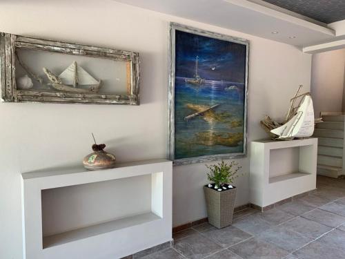 um quarto com duas prateleiras brancas e uma pintura na parede em Bella Vista Apartments Keramoti em Keramoti