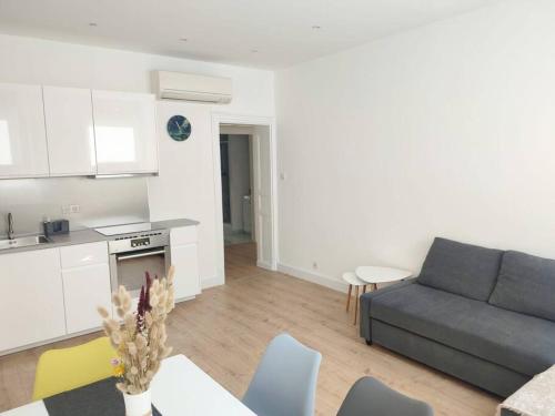 Il dispose d'une cuisine et d'un salon avec un canapé et une table. dans l'établissement Appartement Strasbourg Centre, à Strasbourg