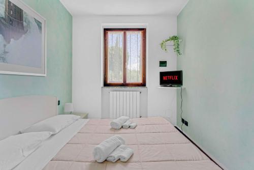 a white bedroom with two towels on a bed at -Free Parking & Pool- Casa a pochi passi dal Lago in Padenghe sul Garda