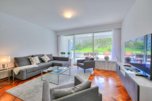 un soggiorno con divano e TV di Residenza Parco Carona a Lugano