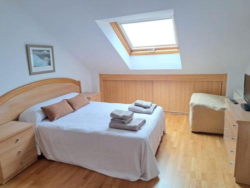 a bedroom with a bed with towels on it at Casa Antonia Portosín in Portosin