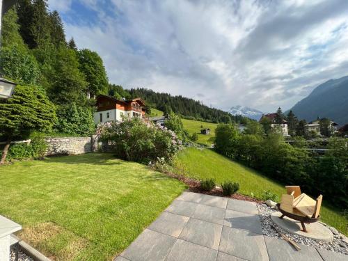 einen Garten mit einer Bank und einem Haus in der Unterkunft Charming chalet with sauna + views! in Bad Gastein