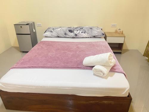 łóżko w pokoju z dwoma ręcznikami w obiekcie Summer room B w mieście Dumaguete
