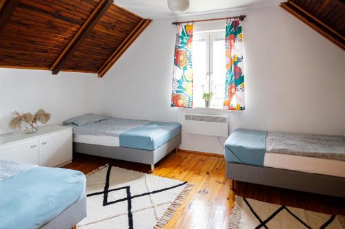 a bedroom with two beds and a window at Holiday home Jarzębinowa 9 in Rowy