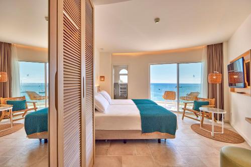 a bedroom with a bed and a view of the ocean at Universal Hotel Aquamarin in Sant Elm