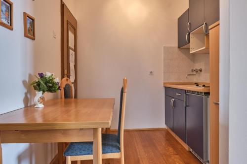 a kitchen with a wooden table and a dining room at Villa Residence Icici in Ičići