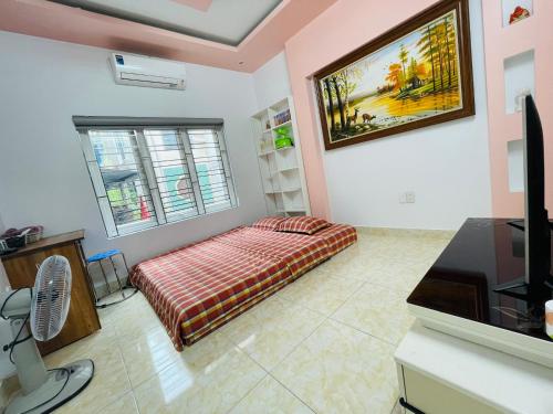 a room with a bed and a tv in it at GM Homestay in Hai Phong
