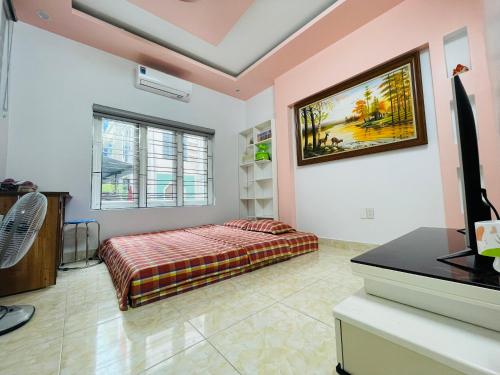 1 dormitorio con 1 cama y TV. en GM Homestay, en Hai Phong
