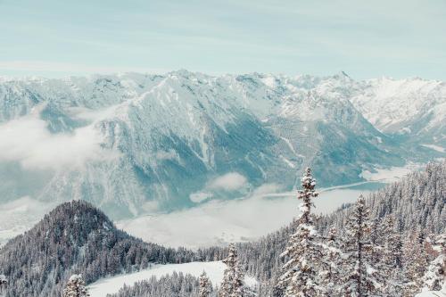 a view of a snow covered mountain range with a lake at Hotel St. Georg zum See in Maurach