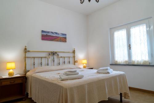 1 dormitorio con 1 cama con toallas en CASA TERESA, en Loppeglia