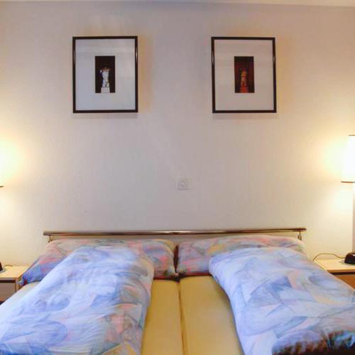 a bed in a room with two pictures on the wall at Gasthaus zum Bären in Bözen